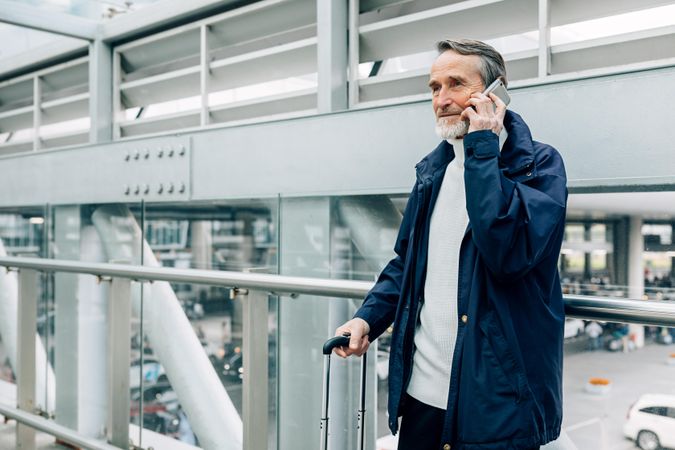 Older man taking phone call outside of airport