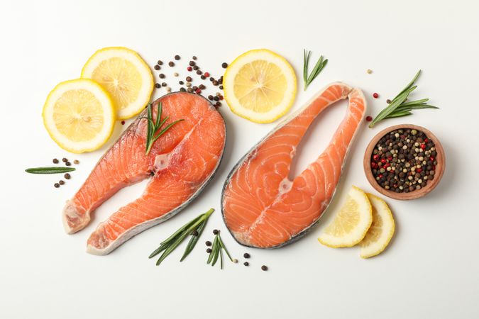 Composition with salmon meat and spices on light background, top view