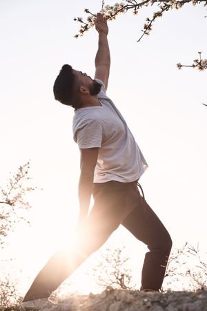 Man doing yoga in spring garden