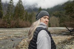 Woman looking at camera standing in the woods