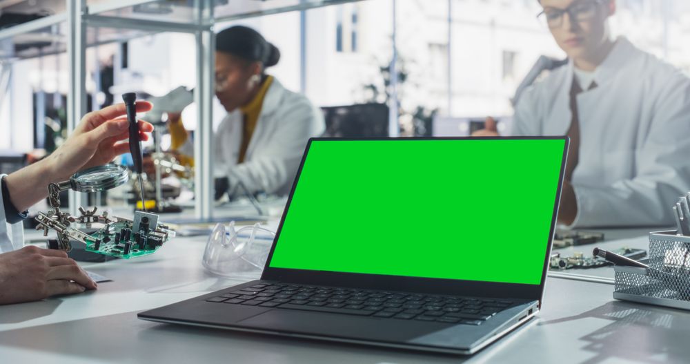 Laptop Computer with Green Screen Mock Up Display Standing on a Table in a Science Class Laboratory.