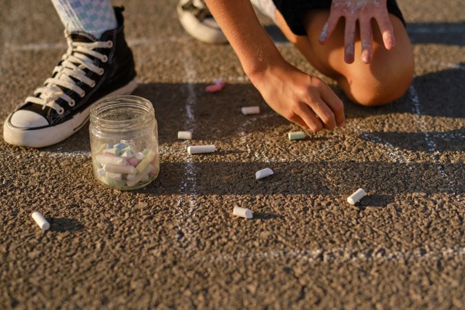 Crop child drawing on asphalt road