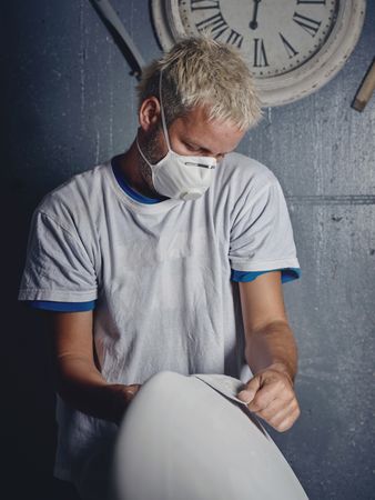 Concentrated male shaper grinding surfboard