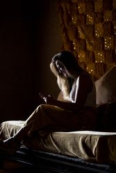 Smiling woman using smartphone in dark room
