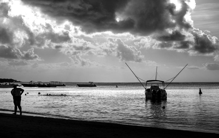 B&W shot looking out to the ocean in Mauritius with boast and person