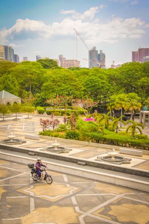 Top view of a person riding a bicycle in a garden in city