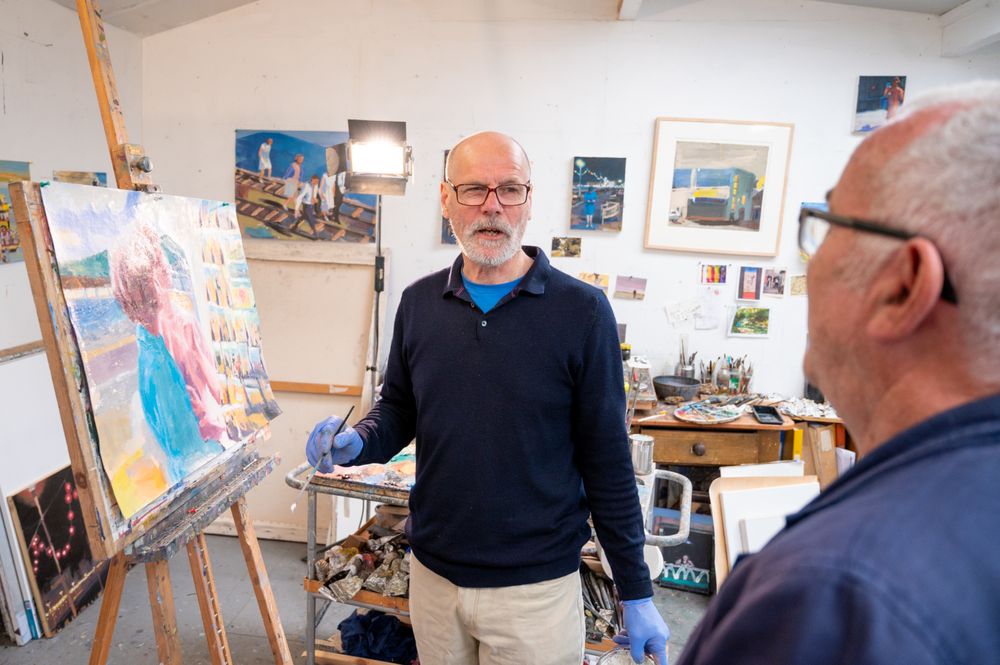 Male artist talking to friend in art studio