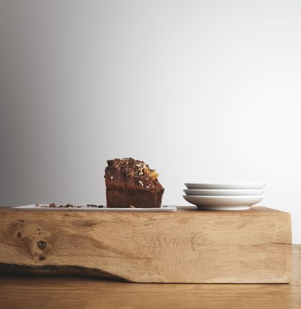 Side view of coffee cake and plates on wooden board