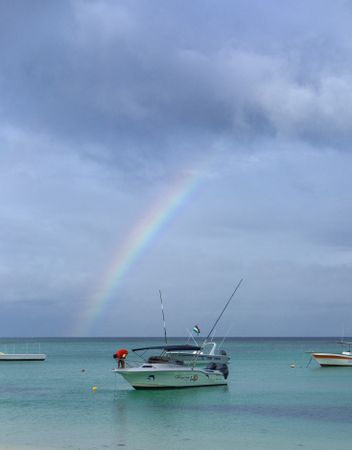 Man on boat under rainbow