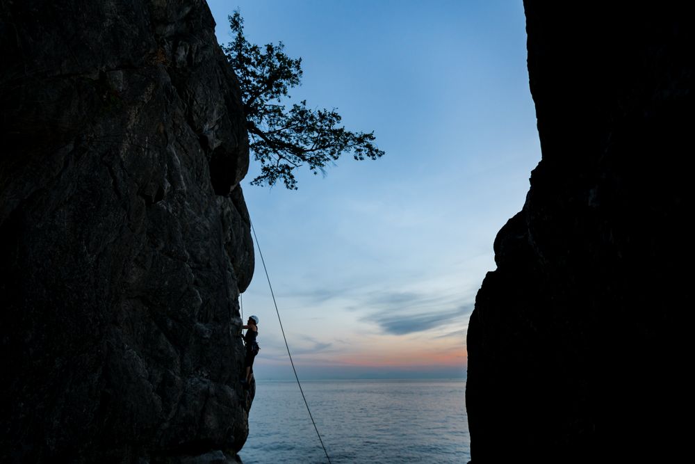 Silhouette of person climbing mountain