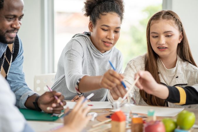 Happy teenage students in painting class