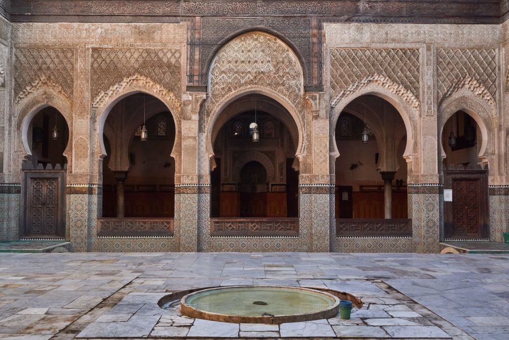 Big container with water near ancient building with vintage doors