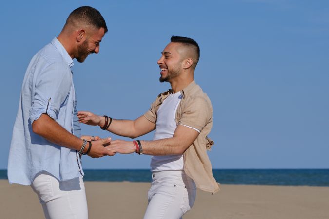 Happy gay couple having fun on beach