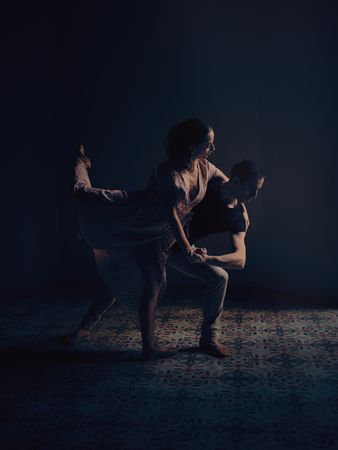 Ballet dancers performing dance in dark studio