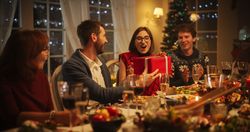 Parents and Relatives Enjoying Christmas Dinner Together in a Cozy Home in the Evening.
