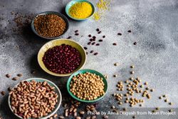 Variety of dried grains and legumes from pantry on grey counter with copy space 0KME6V