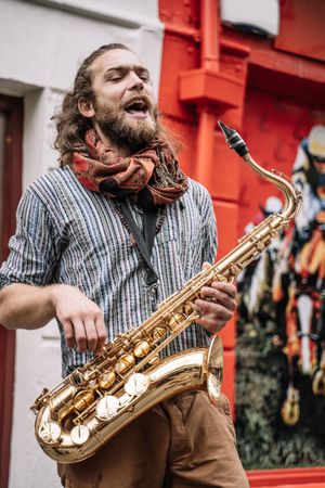 Male saxophonist plays Sax in the street