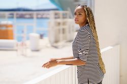 Female leaning on railing of the pier looking around