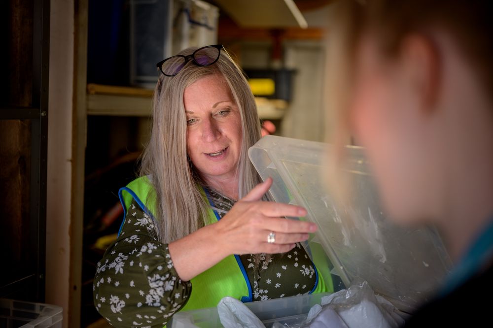 Older woman looking into a bin in stock room