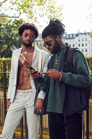 London, England, United Kingdom - September 15th, 2019: Two men outside in London, looking at phone