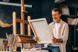 Man looking at his painting in studio