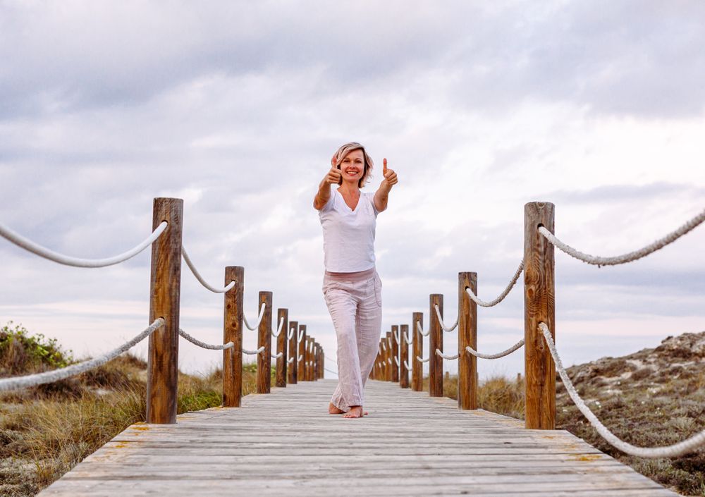 Cheerful woman exercising on timber path