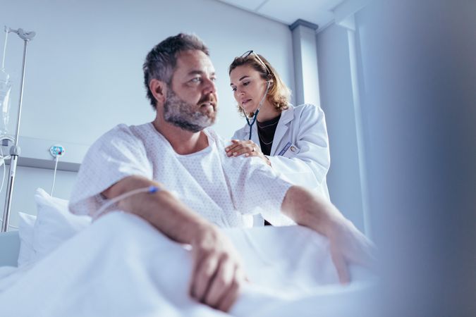 Hospitalized man getting examined by female physician