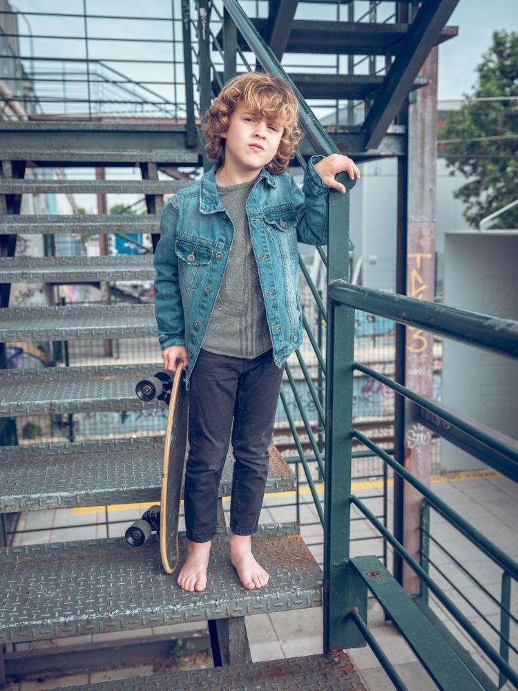 Barefoot kid with skateboard on staircase
