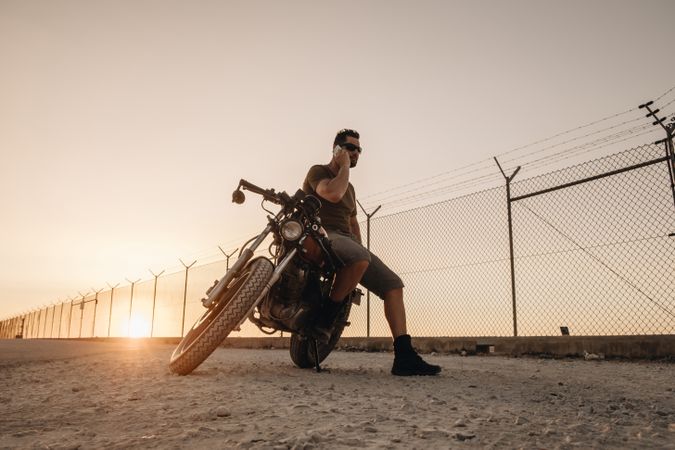 Man sitting on motorcycle and surfing mobile