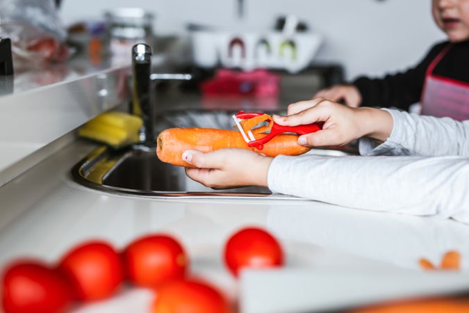Anonymous girls preparing vegetables for salad