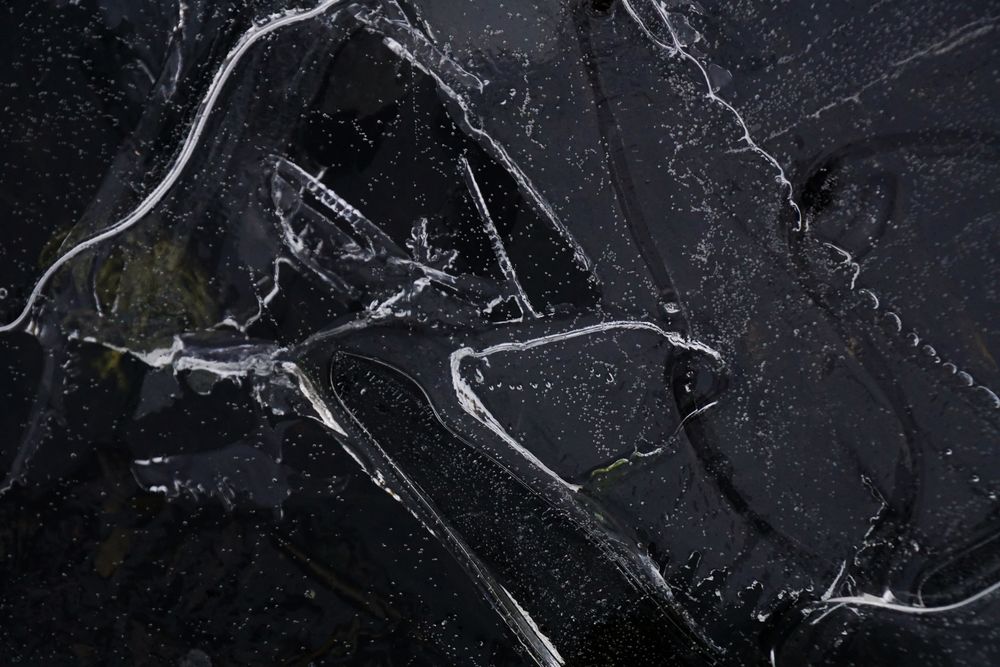 Fragment of thin ice on dark frozen river