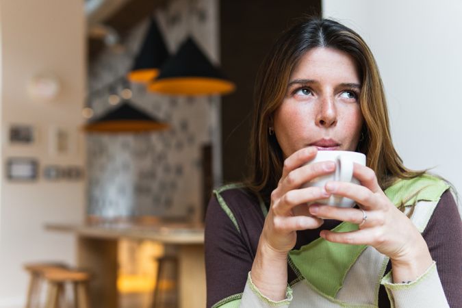 Contemplative woman with cup of coffee in cafe