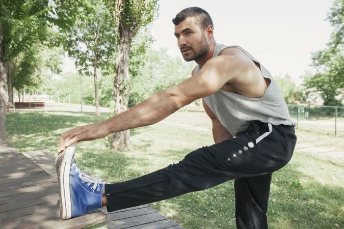 Sportsman stretching body in park