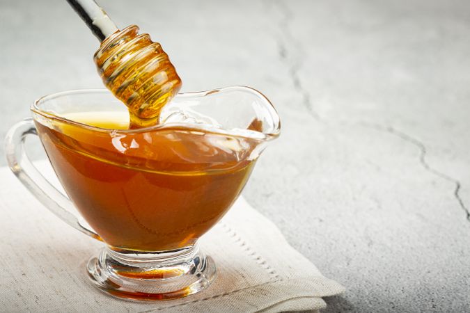 Honey in glass bowl on the table.