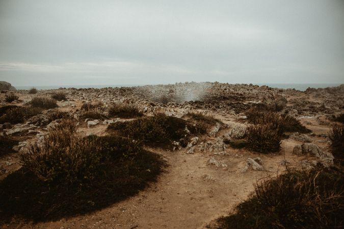Crater between land and cloudy sky