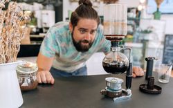 Barista skillfully brewing specialty coffee with Japanese siphon coffee maker