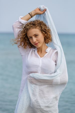 Young woman with sash near water