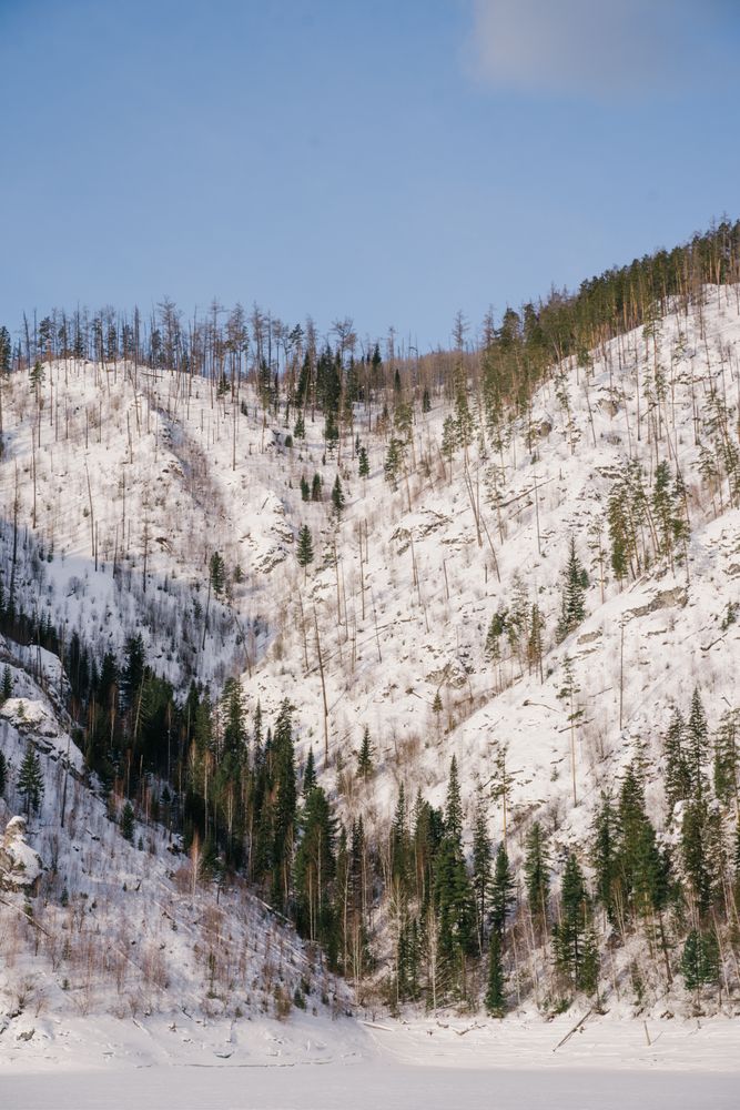 Winter landscape with snowy rocks and blue sky