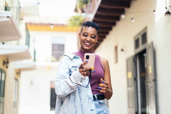 Cool Latin American woman using smartphone in the city