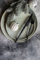 Top view of Christmas table setting with pine branch and snowy baubles