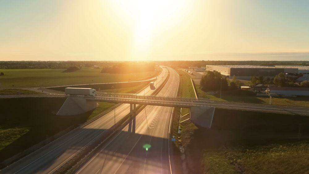 Aerial View of Semi Truck with Cargo Trailer Passing Highway Overpass