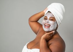 Cheerful Black woman with mud mask