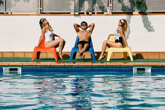 a group of young models by the pool with sunglasses