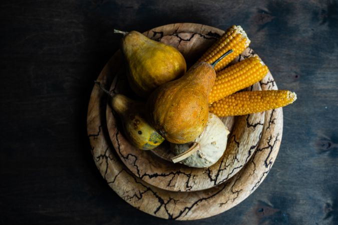 Rustic plate with corn and gourds in autumnal table setting