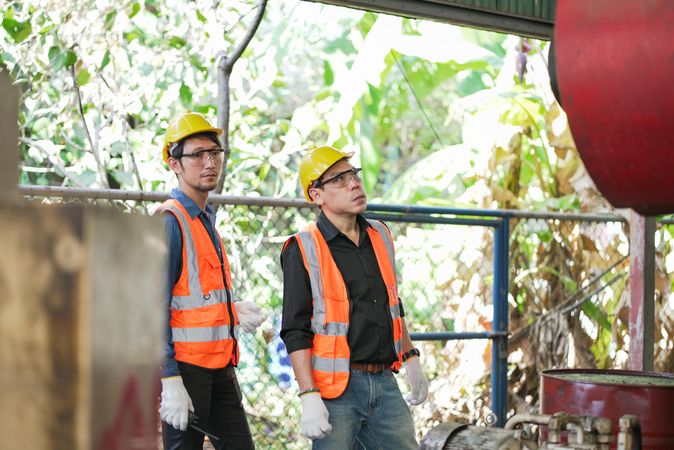 Two Asian engineer or technician workers standing in old factory