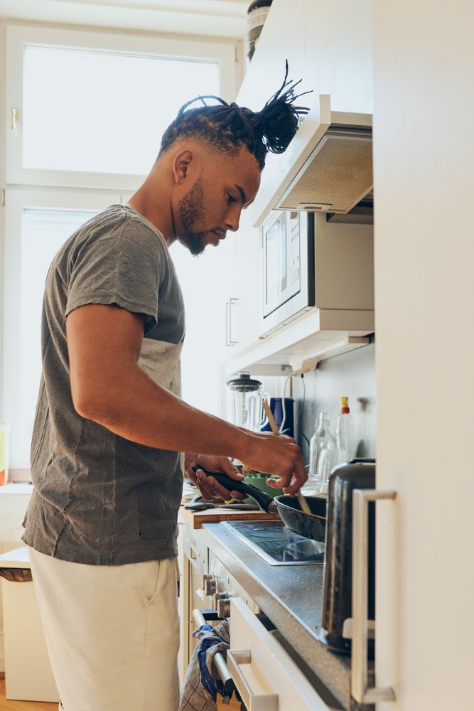 Young Black male cooking dinner
