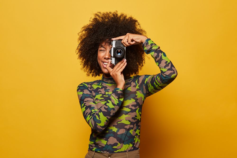 Trendy female paparazzi holding camera
