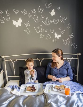 Mother and son having breakfast in bed