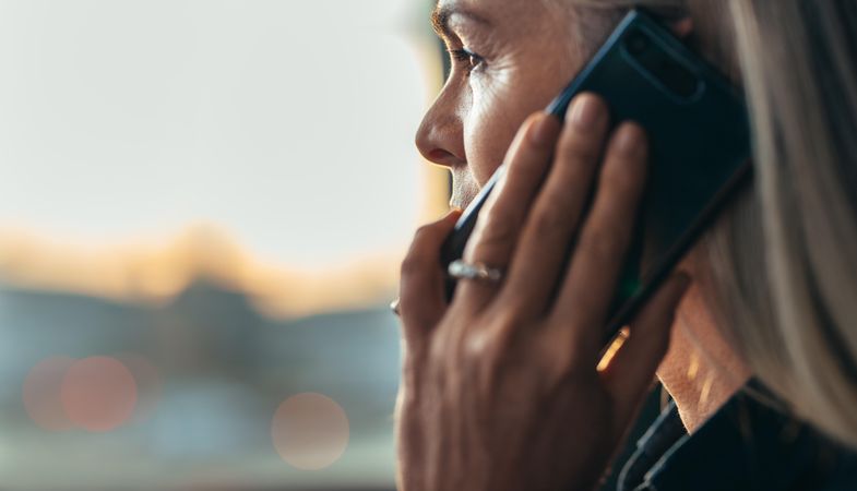 Close up side view of business woman making a phone call