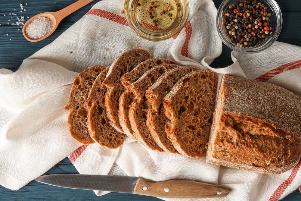 Composition with freshly baked bread on wooden background, top view